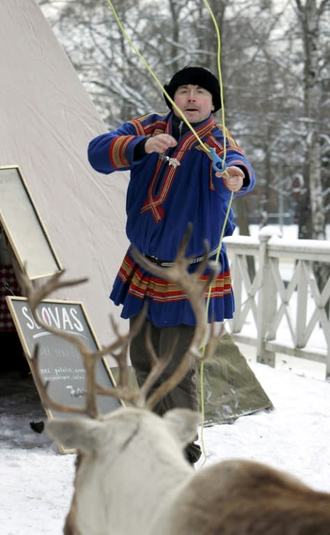 A Sami man in traditional dress using a lasso