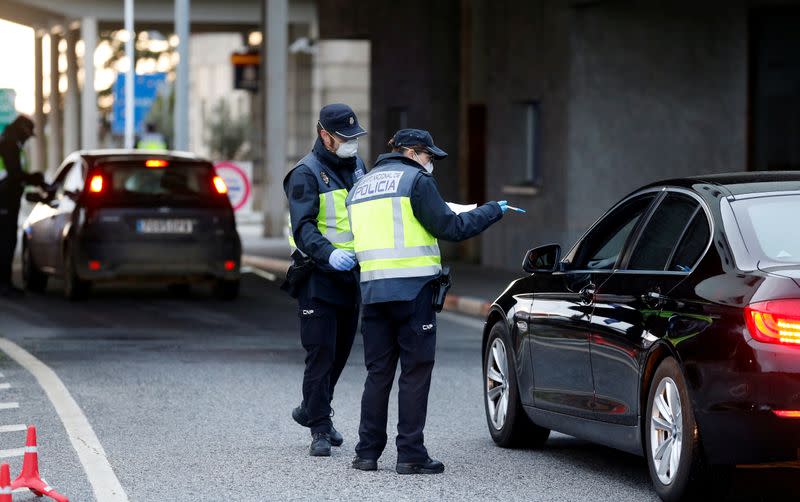 Un policía revisa un coche en la frontera entre Portugal y España, siguiendo una orden del gobierno español de establecer controles en sus fronteras terrestres sobre el coronavirus, en Vilar Formoso, Portugal, el 17 de marzo de 2020