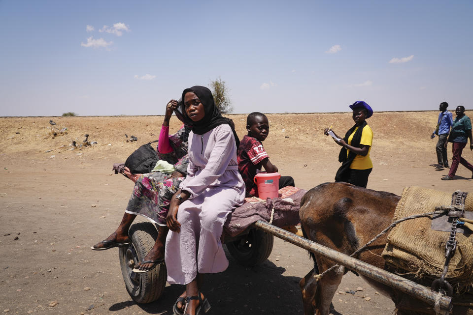 People cross the border from Sudan to South Sudan on a donkey cart and check in with border monitoring staff, at the Joda border crossing in South Sudan Tuesday, May 16, 2023. Tens of thousands of South Sudanese are flocking home from neighboring Sudan, which erupted in violence last month. (AP Photo/Sam Mednick)