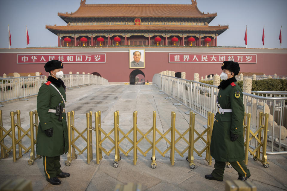 Los guardias con máscaras sanitarias en la Puerta Tiananmen, cerca de la Plaza Tiananmen, en Beijing, el 27 de enero del 2020. (AP Photo/Mark Schiefelbein)