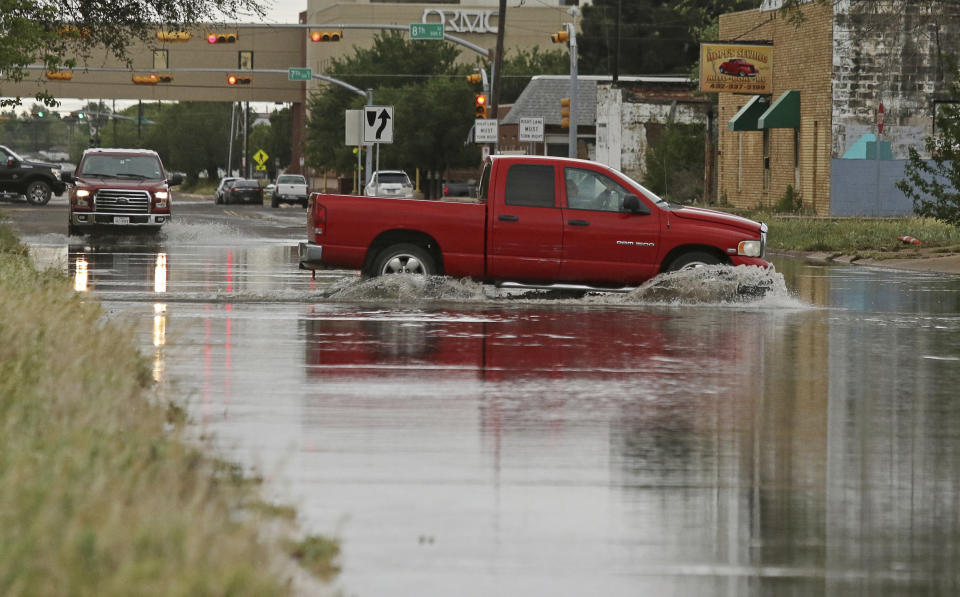 A vehicle drives through a flooded section of Muskingum Avenue on Saturday, April,13, 2019, in Odessa, Texas. (Jacob Ford/Odessa American via AP)