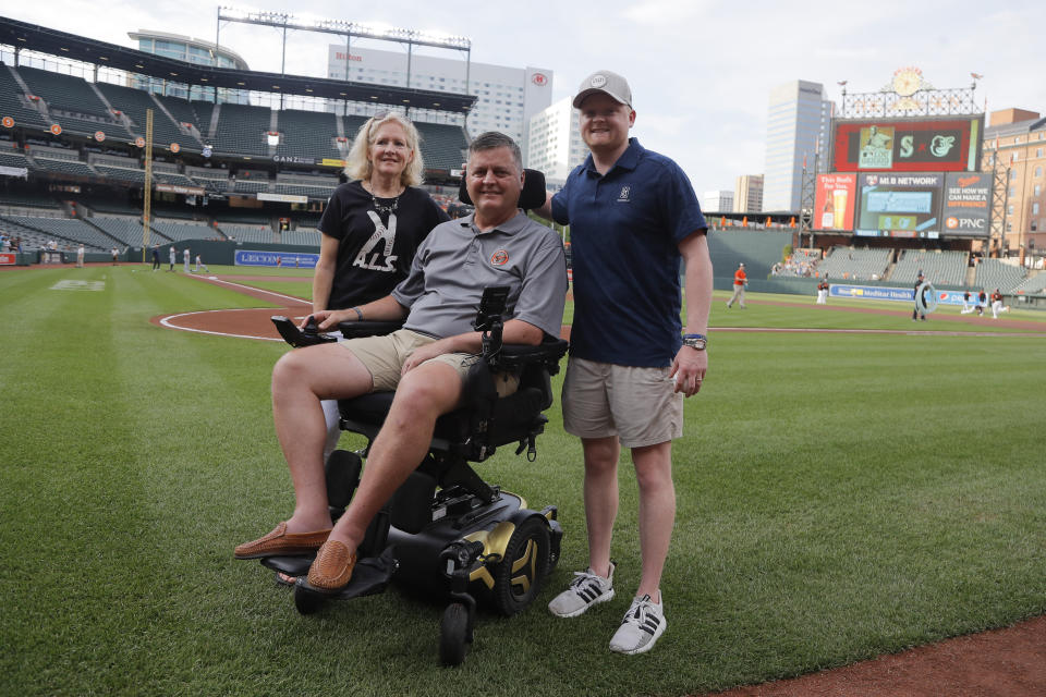 FILE - Former Baltimore Orioles pitcher Jim Poole, center, poses for a photo with his wife, Kim Poole, left, and their son Hayden Poole, prior to a baseball game between the Orioles and the Seattle Mariners, Thursday, June 2, 2022, in Baltimore. Poole, who pitched in the big leagues for 11 seasons and surrendered the deciding homer to Atlanta's David Justice in the 1995 World Series, died of complications from ALS, Friday, Oct. 6, 2023. He was 57. (AP Photo/Julio Cortez, File)