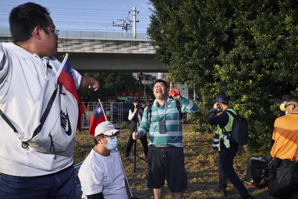 A man looks over his shoulder as another man speaks