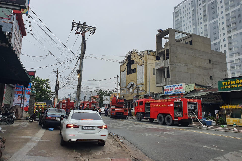 Fire department trucks line outside a karaoke parlor following a fire Wednesday, Sept. 7, 2022, in Thuan An city, southern Vietnam. Over a dozen people died in the fire local media reported. (Duong Trei Tuong/VNA via AP)