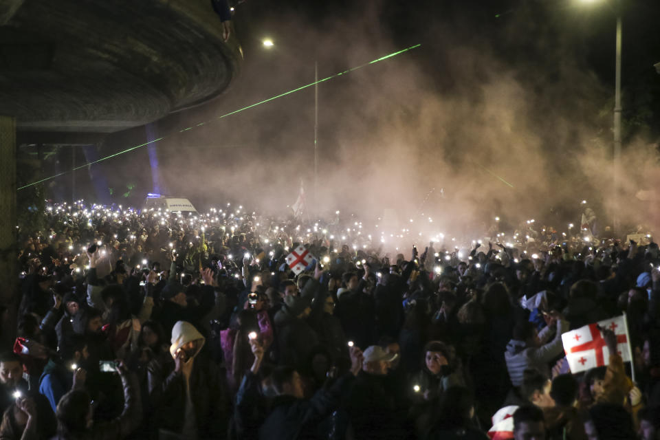 Demonstrators hold up their smart phones with the torch light switched on as they gather in the Square of Heroes during an opposition protest against "the Russian law" in the center of Tbilisi, Georgia, Tuesday, May 14, 2024. The Georgian parliament on Tuesday approved in the third and final reading a divisive bill that sparked weeks of mass protests, with critics seeing it as a threat to democratic freedoms and the country's aspirations to join the European Union. (AP Photo/Zurab Tsertsvadze)