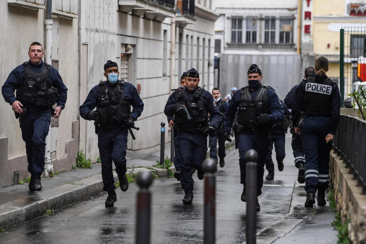 French police officers rush to the scene after people were injured near the former offices of the French satirical magazine Charlie Hebdo: AFP via Getty Images