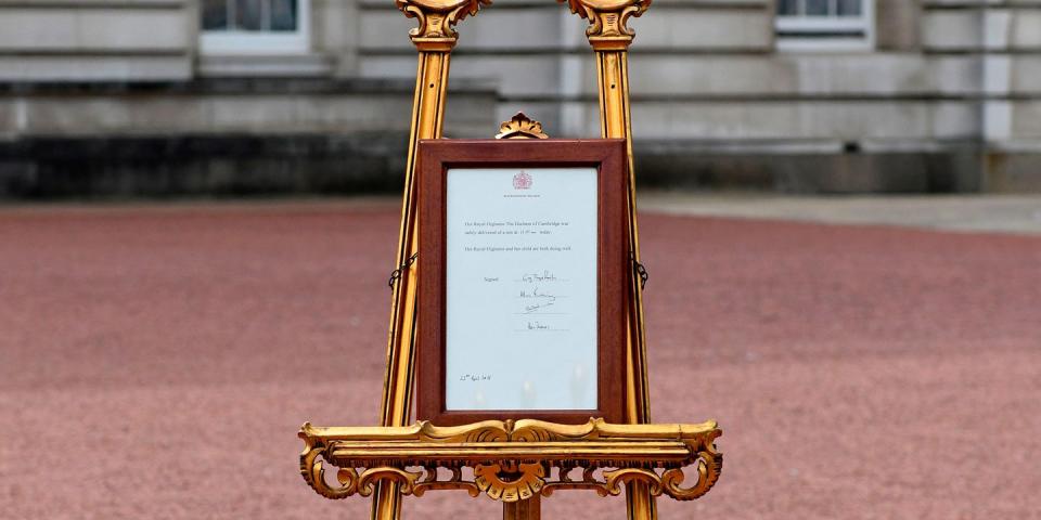 7) The birth announcement is displayed on an easel outside Buckingham Palace