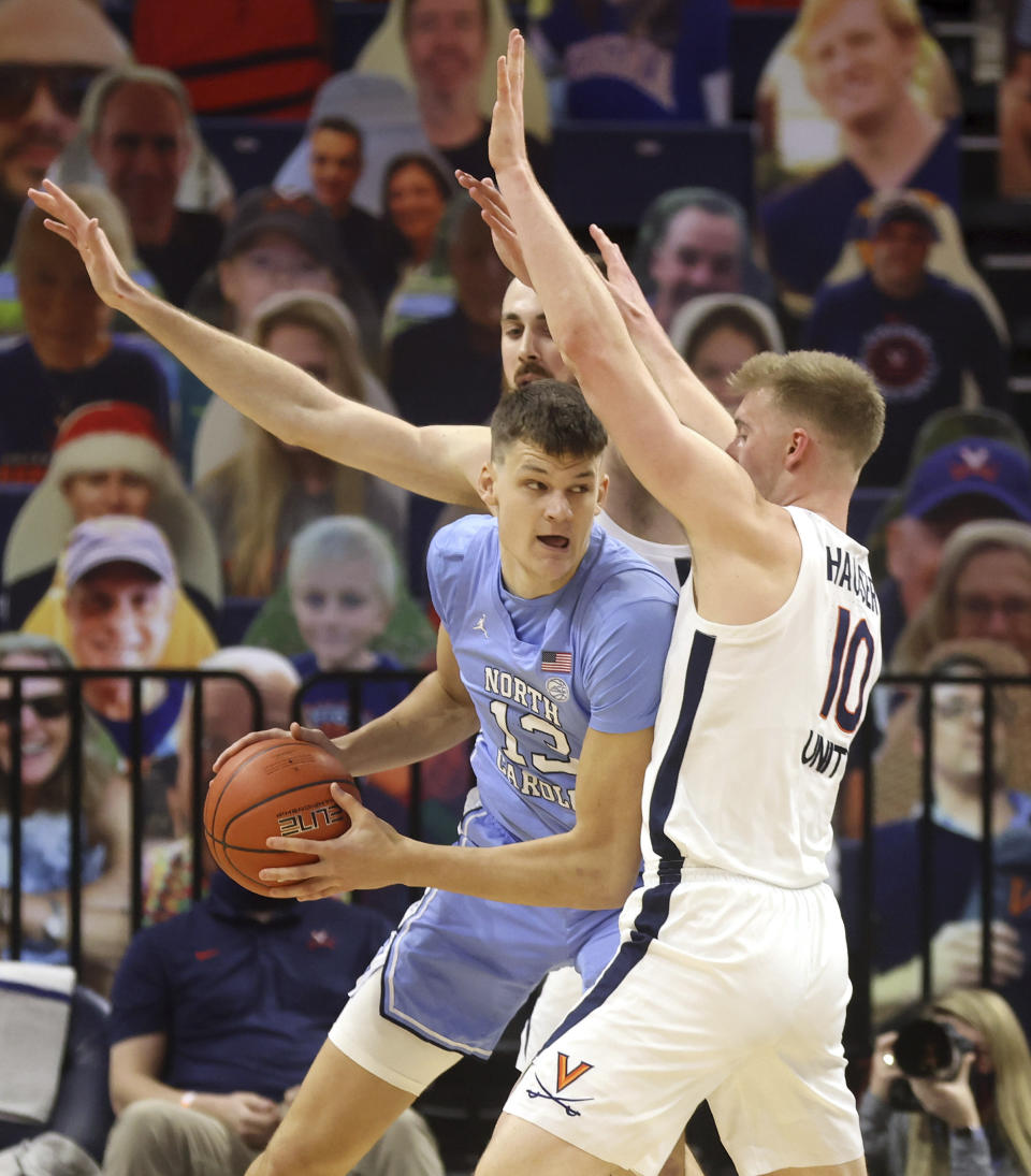 North Carolina's Walker Kessler, left, is pressured by Virginia forward Sam Hauser (10) and forward Jay Huff during an NCAA college basketball game Saturday, Feb. 13, 2021, in Charlottesville, Va. (Andrew Shurtleff/The Daily Progress via AP, Pool)