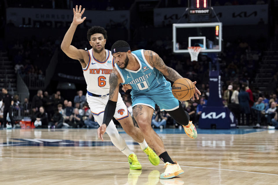 Charlotte Hornets forward Miles Bridges (0) drives to the basket while guarded by New York Knicks guard Quentin Grimes (6) during the first half of an NBA basketball game Monday, Jan. 29, 2024, in Charlotte, N.C. (AP Photo/Jacob Kupferman)