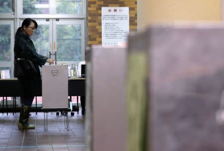 A voter casts her ballot for a national election at a polling station in Tokyo, Japan October 22, 2017. REUTERS/Kim Kyung-Hoon