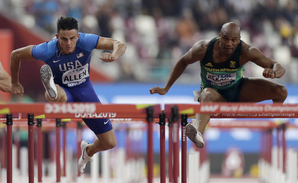 Devon Allen, of the United States, left, and Antonio Alkana, of South Africa, compete in the men's 110 meter hurdles heats at the World Athletics Championships in Doha, Qatar, Monday, Sept. 30, 2019. (AP Photo/Petr David Josek)