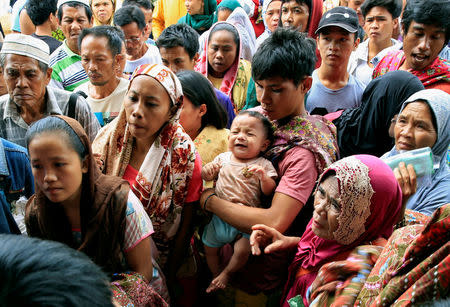 Evacuees wait for their names to be called to get relief goods, after fleeing to an evacuation centre to avoid the fighting in Marawi between the government troops and Islamic State-linked militants, in Saguiaran town, Lanao Del Sur, southern Philippines September 10, 2017. REUTERS/Romeo Ranoco