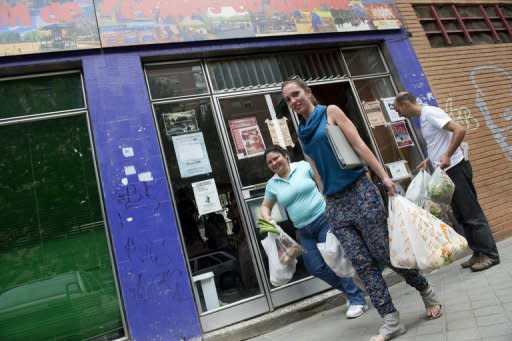 People carry bags filled up with fruits and vegetables for distribution to the needy, in a working class neighbourhood of Madrid, on June 1. Spain's "indignants" are currently building an extraordinary street-level network to help those hardest hit by economic hardship