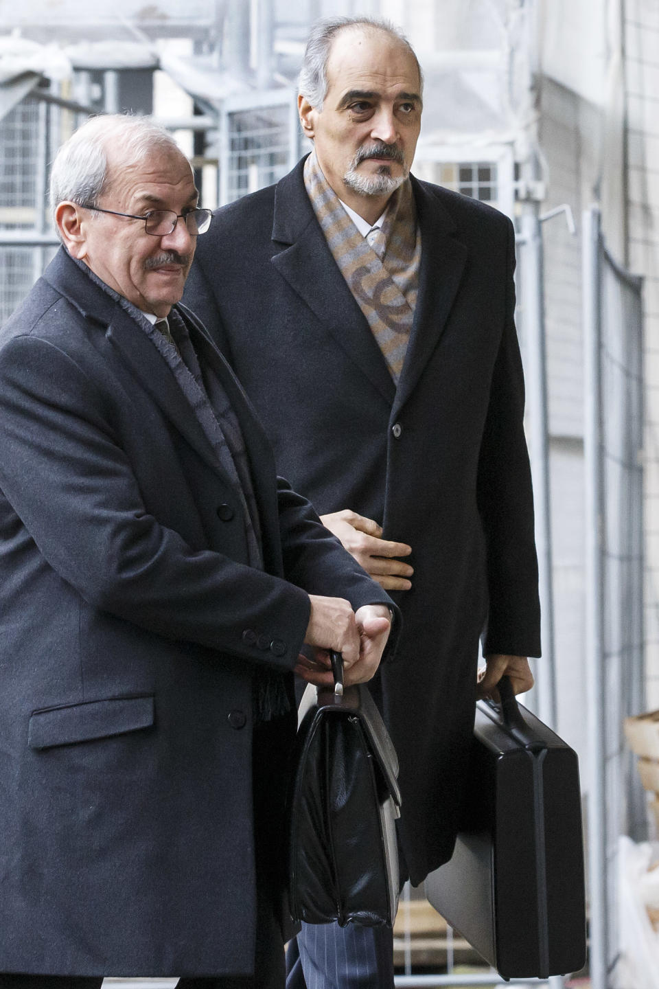 Syrian chief negotiator Bashar Jaafari, Ambassador of the Permanent Representative Mission of Syria to the UN in New York, right, arrives for a meeting during the second round of negotiations between the Syrian government and the opposition at the European headquarters of the United Nations, in Geneva, Switzerland, Saturday, Feb. 15, 2014. Person at left is not identified. (AP Photo/Keystone, Salvatore Di Nolfi)