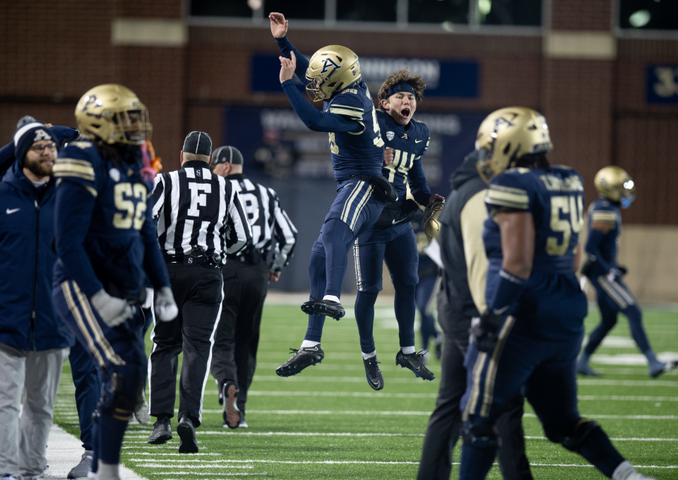 Players on the University of Akron sideline celebrate a comeback win over Kent State on Wednesday night in Akron.