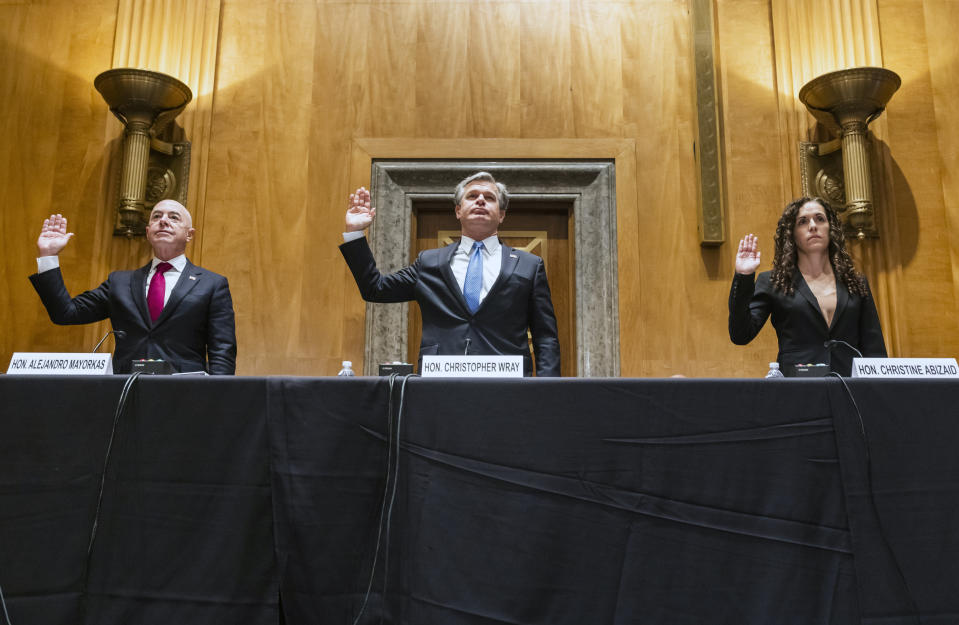 Secretary of Homeland Security Alejandro Mayorkas, left, FBI Director Christopher Wray, center, and Director of the National Counterterrorism Center Christine Abizaid, are sworn-in prior to testifying before a Senate Homeland Security and Governmental Affairs Committee hearing to discuss security threats 20 years after the 9/11 terrorist attacks, Tuesday, Sept. 21, 2021 on Capitol Hill in Washington. (Jim Lo Scalzo/Pool via AP)