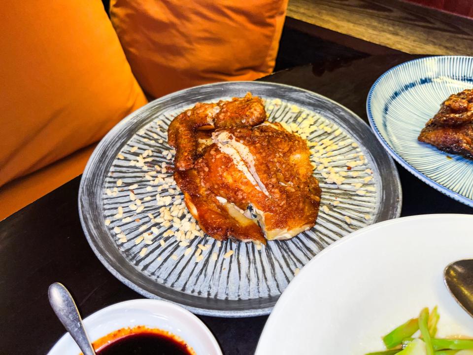 A blue plate with a small piece of golden-brown chicken. The chicken is cut down the center, revealing white meat.