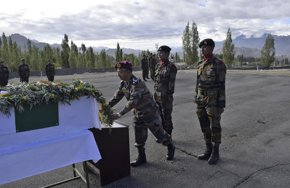 In this photo provided by the Indian Army, an officer lays a wreath in front of the remains of Chandra Shekhar, an Indian army soldier found more than 38 years after he went missing, in Leh, India, Wednesday, Aug. 17, 2022. The soldier and 17 other colleagues were occupying a ridge on Siachen Glacier, high in the Karakoram range in disputed Kashmir's Ladakh region, in May 1984 when they were hit by an avalanche, officials said. (Indian Army via AP)