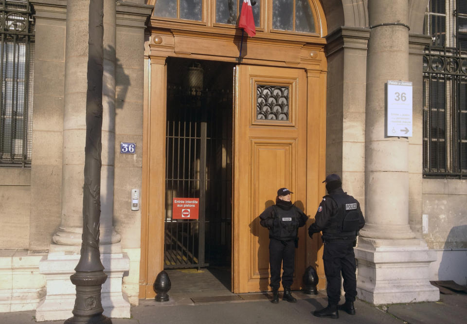 FILE - In this Friday, Feb. 6, 2015 file picture, police officers stand guard in front of the 36 Quai des Orfevres police headquarters in Paris, France. Two anti-gang French policemen are going on trial over charges of gang-raping a Canadian tourist at Paris police headquarters. (AP Photo/Francois Mori, File)