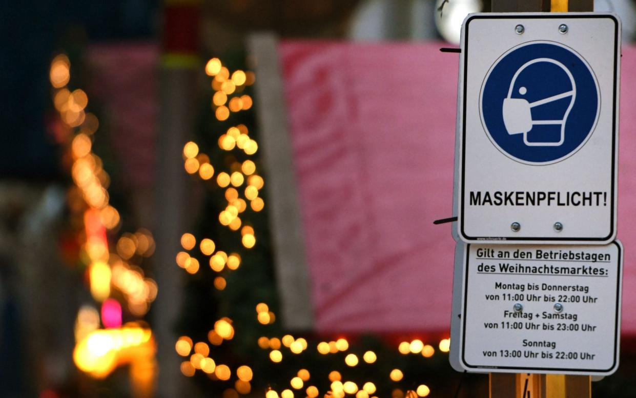 A sign indicating an obligation to wear face masks is seen at the Christmas market in the city of Duisburg, western Germany on Nov 29 - AFP