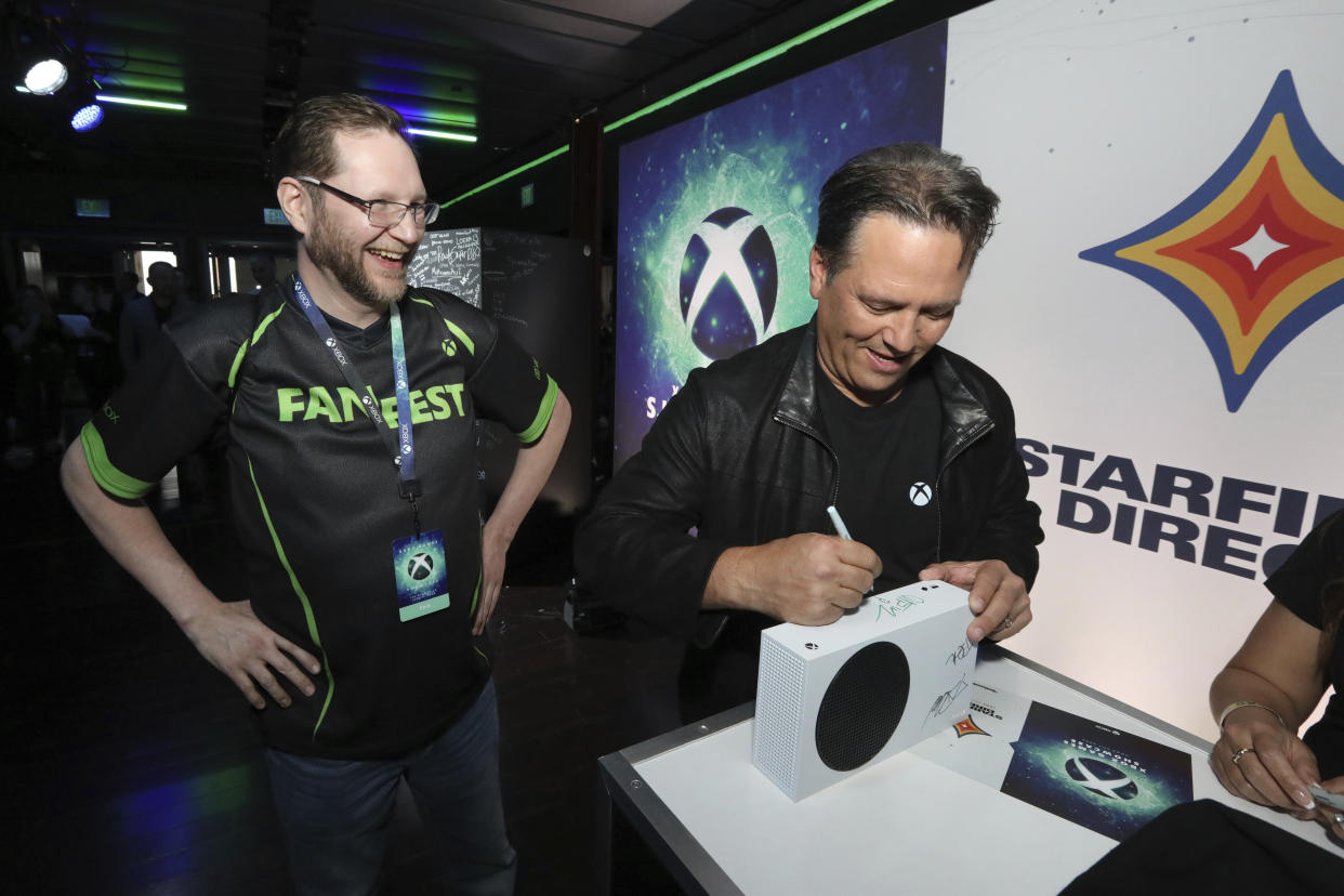 IMAGE DISTRIBUTED FOR XBOX - Phil Spencer, right, Head of Xbox, signs a fan's console during a meet and greet at the 2023 Xbox FanFest on Sunday, June 11, 2023 in Los Angeles. (Casey Rodgers/AP Images for Xbox)