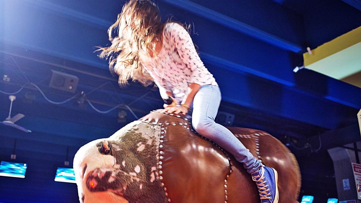low angle view of woman on mechanical bull in nightclub