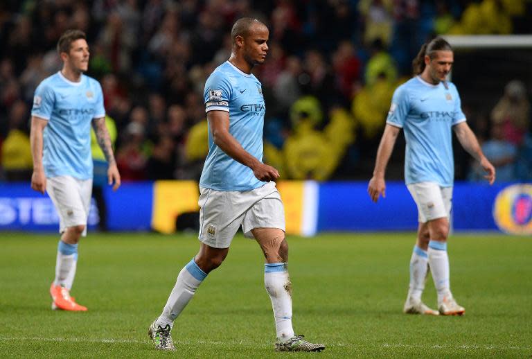 Manchester City's Belgian midfielder Vincent Kompany (C) leaves the pitch at the final whistle with Montenegrin forward Stevan Jovetic (L) and Argentinian defender Martín Demichelis at the Etihad Stadium in Manchester on April 16, 2014