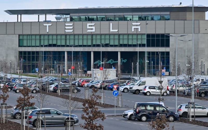 Cars belonging to employees of the Tesla Gigafactory Berlin-Brandenburg parked outside the factory. Production at the Tesla car factory in Gruenheide is at a standstill due to a power outage following an arson attack on a high-voltage pylon. The police are investigating suspected arson following a power failure on 5 March morning. Patrick Pleul/dpa
