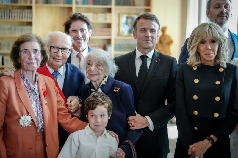 Emmanuel Macron (2-R), President of France, and his wife Brigitte (R) stand together in the French Embassy after the medal ceremony for Beate (left) and Serge Klarsfeld (2-L) and Holocaust survivor Margot Friedlaender (C). Kay Nietfeld/dpa-Pool/dpa