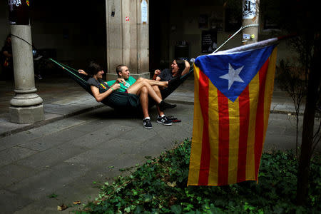 Students rest next to an Estelada (Catalan separatist flag) in the University of Barcelona's historic building after thousands of students occupied it during a protest in favor of the banned October 1 independence referendum, in Barcelona, Spain, September 25, 2017. REUTERS/Jon Nazca