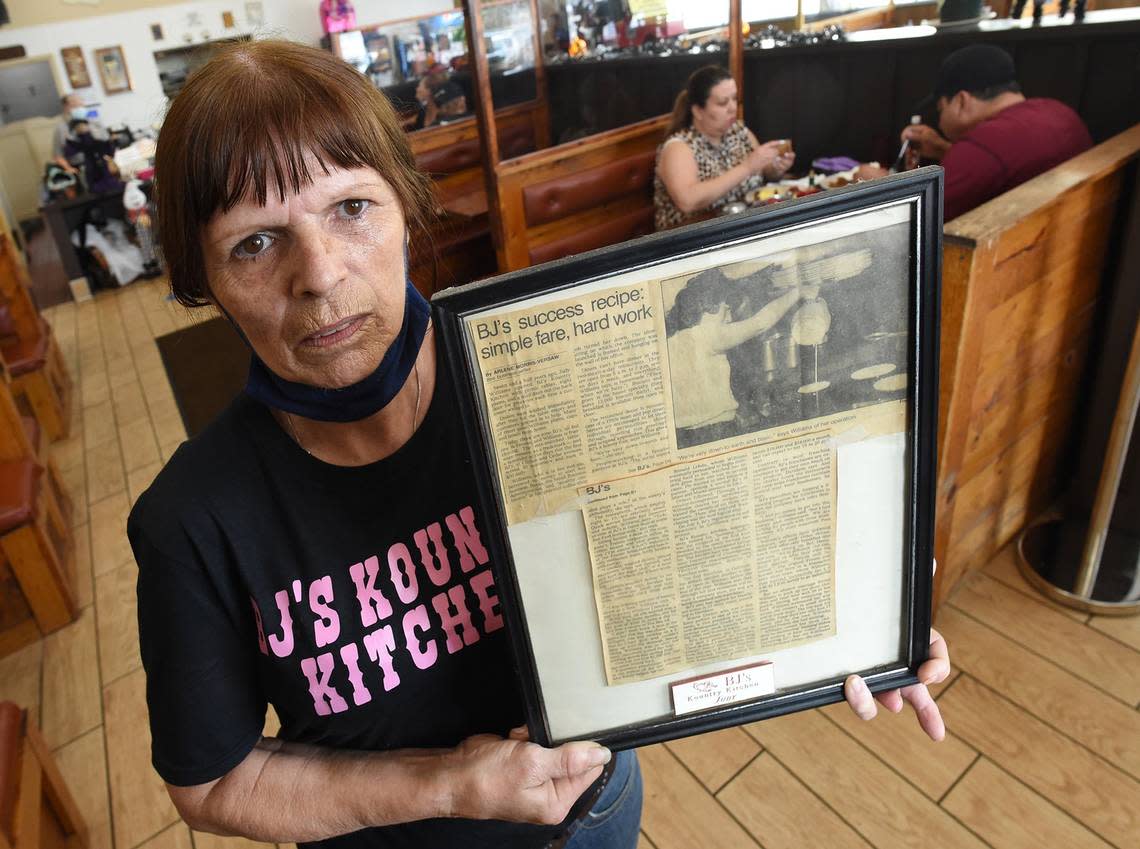 Owner of the original BJ’s Kountry Kitchen, Lynda Wiens – holding a newspaper article about the restaurant from the late 1980s – is pictured in this file photo from 2020, when the restaurant started a GoFundMe campaign to stay afloat. The restaurant closed in early October, but a new owner has stepped in and will reopen it. Wiens will stay on to cook.