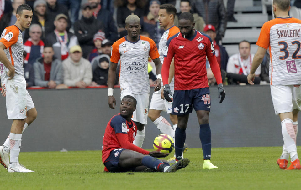 Lille's Nicolas Pepe, center, on the ground during his French League One soccer match between Lille and Montpellier at the Lille Metropole stadium, in Villeneuve d'Ascq, northern France, Sunday, Feb. 17, 2019. (AP Photo/Michel Spingler)