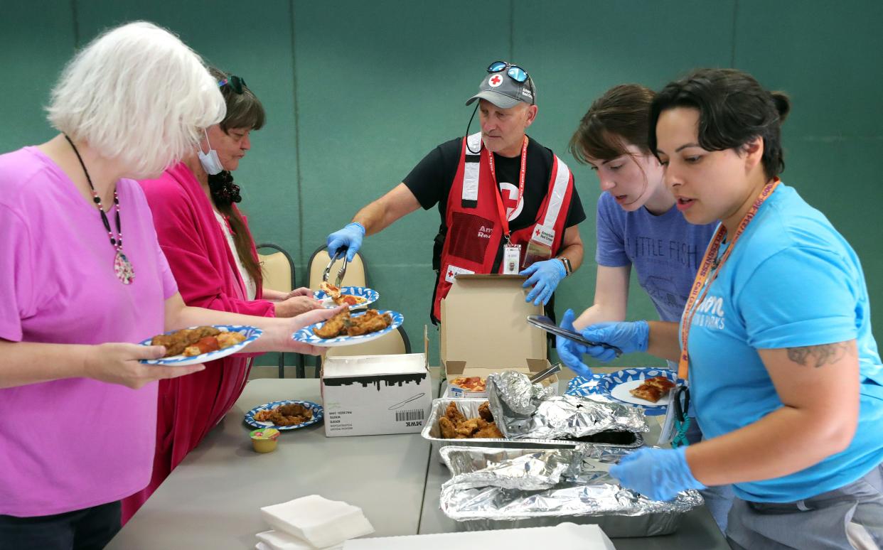 Tim Ricks of the American Red Cross, center, helps provide a meal to displaced residents at Firestone Park Community Center after a chemical fire on Rosemary Boulevard forced them to evacuate their homes, Thursday, Sept. 5, 2024, in Akron, Ohio.