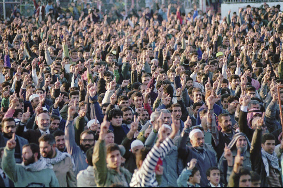 FILE - Thousands of Palestinans affiliated with the militant Muslim group Hamas raise their hands as they vow to continue its holy war against Israel and to boycott the Jan. 20th Palestinian elections during a rally in Gaza City Saturday Dec. 16, 1995. The gathering marked the eighth anniversary of Hamas. (AP Photo/Adel Hana, File)