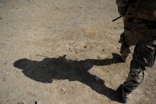 A US soldier patrols a village in Kandahar province, southern Afghanistan in 2010. The White House and NATO on Wednesday condemned grisly photographs showing US soldiers with the mangled remains of suspected Taliban suicide bombers in Afghanistan