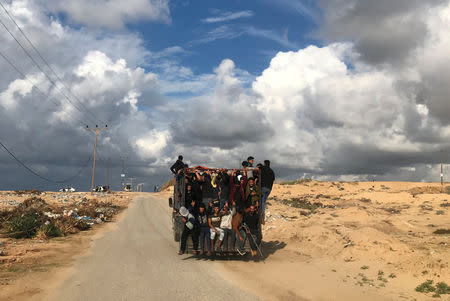 FILE PHOTO: Palestinians ride a truck on their way to a protest calling for lifting the Israeli blockade on Gaza, near the beachfront border with Israel, in the northern Gaza Strip November 5, 2018. REUTERS/Mohammed Salem/File Photo