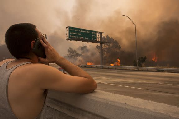 A man watches to see if his house and two of his cats on the other side of thick smoke and flames might burn near the Sunland-Tujunga neighborhood on September 2, 2017.