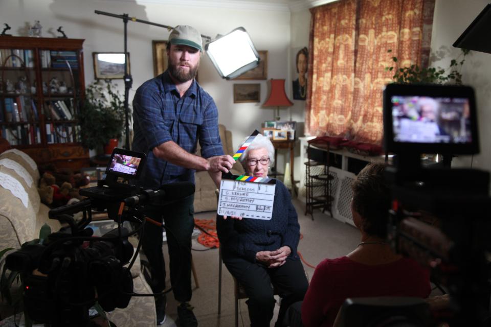 Justin Reddington McCarthy and Eva Schloss prepare for a new take on the set of the documentary "Eva's Promise."