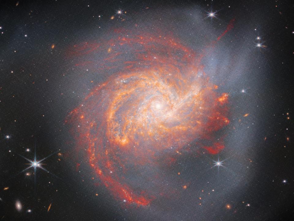 A picture shows galaxy NGC 3256 in infrared light. The spiral galaxy is a peculiar shape because it was formed by two galaxies crashing into each other about 500 million years ago.