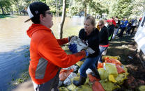 <p>Brady Hoth, left, hands off a sandbag to Doreen Steil as flood cleanup begins in the North Cedar neighborhood Monday, Sept. 26, 2016, in Cedar Falls, Iowa. (Matthew Putney/The Waterloo Courier via AP)</p>