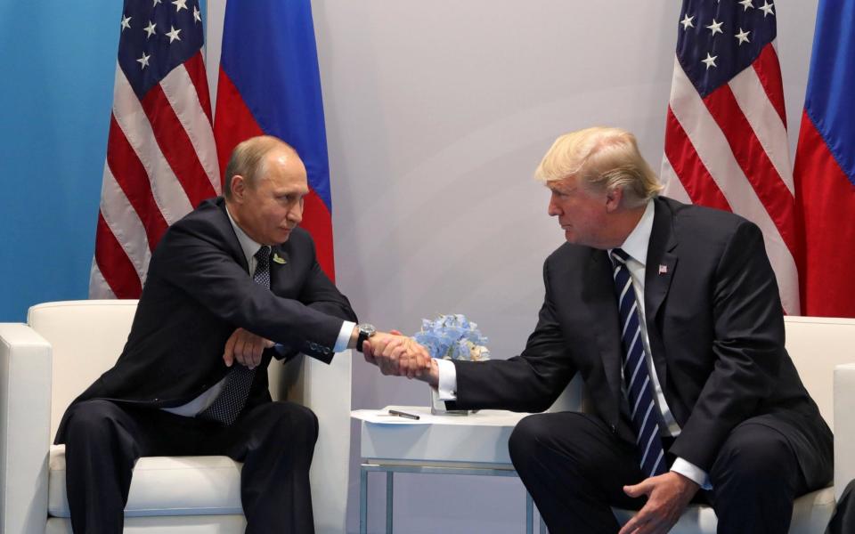 Vladimir Putin and Donald Trump shake hands during their meeting on the sidelines of the G20 summit in Hamburg, Germany, July 7, 2017 - Credit: SPUTNIK 