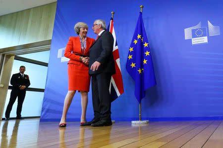 British Prime Minister Theresa May is welcomed by European Commission President Jean-Claude Juncker at the EC headquarters in Brussels, Belgium October 21, 2016. REUTERS/Yves Herman