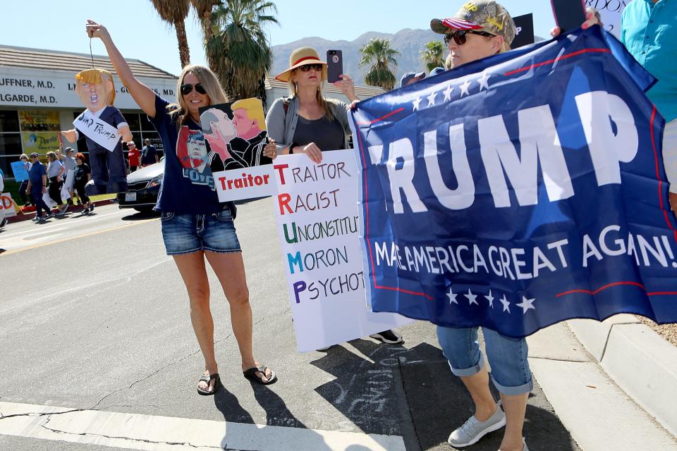 President Trump supporter Vicki Haeberle, right, of La Quinta holds a Trump banner as protesters demonstrate against the President on Highway 111 near Indian Trail in Rancho Mirage, Calif., on Wednesday, February 19, 2020. 