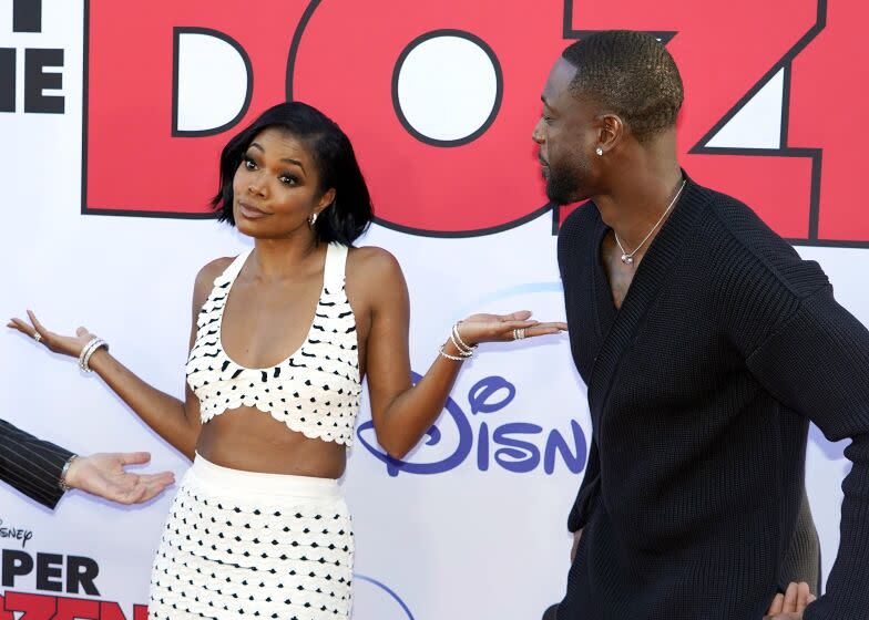 Gabrielle Union, center, a cast member in "Cheaper by the Dozen," poses between fellow cast member Zach Braff, left, and her husband Dwyane Wade at the premiere of the film at the El Capitan Theatre, Wednesday, March 16, 2022, in Los Angeles. (AP Photo/Chris Pizzello)