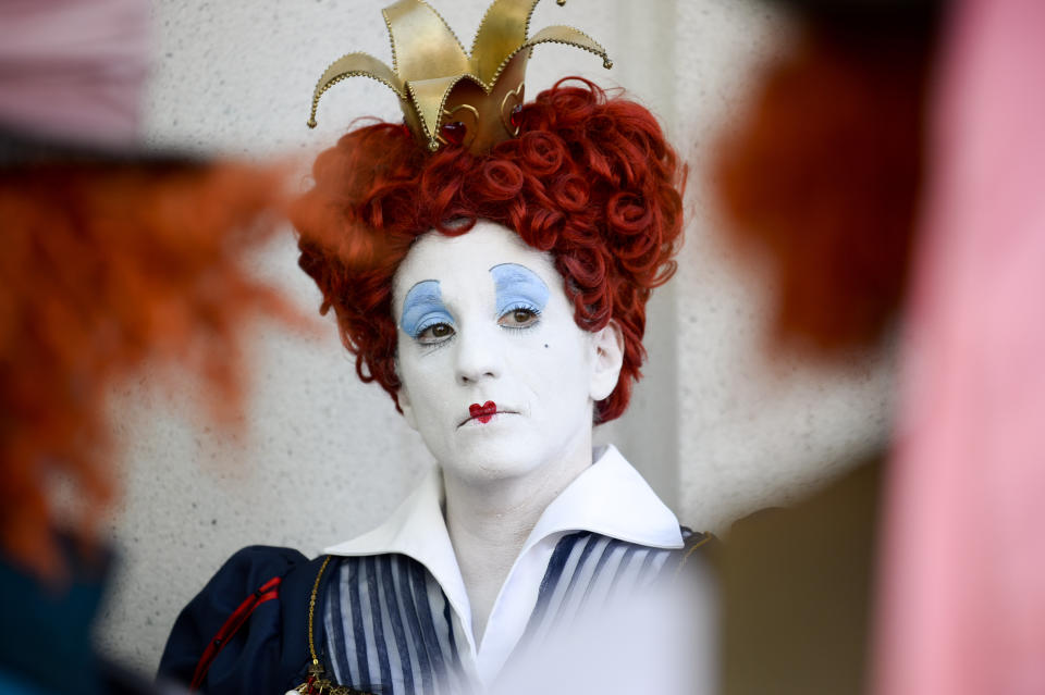 Lorraine Ouellette, a member of the League of Hatters, poses for a photo in between two Mad Hatters on day one of Comic-Con International held at the San Diego Convention Center Thursday, July 21, 2016, in San Diego. (Photo by Denis Poroy/Invision/AP)