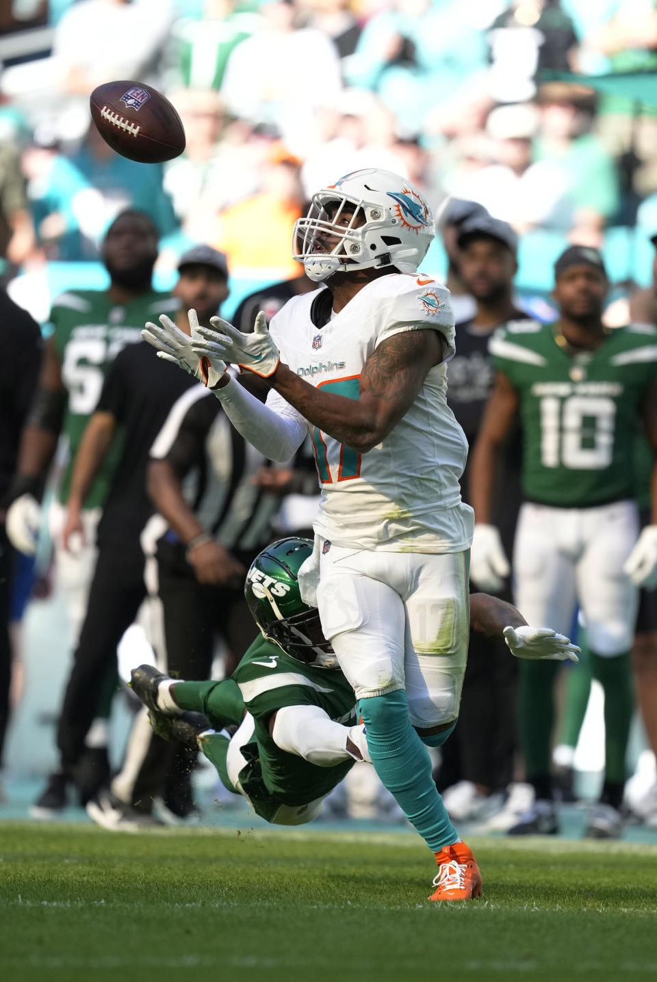 Miami Dolphins wide receiver Jaylen Waddle (17) grabs a pass for a touchdown as New York Jets cornerback D.J. Reed (4) attempts to tackle during the first half of an NFL football game, Sunday, Dec. 17, 2023, in Miami Gardens, Fla. (AP Photo/Rebecca Blackwell)