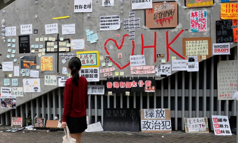 Passer-by looks at notes and placards with messages of support for the protest against the extradition bill in Hong Kong.