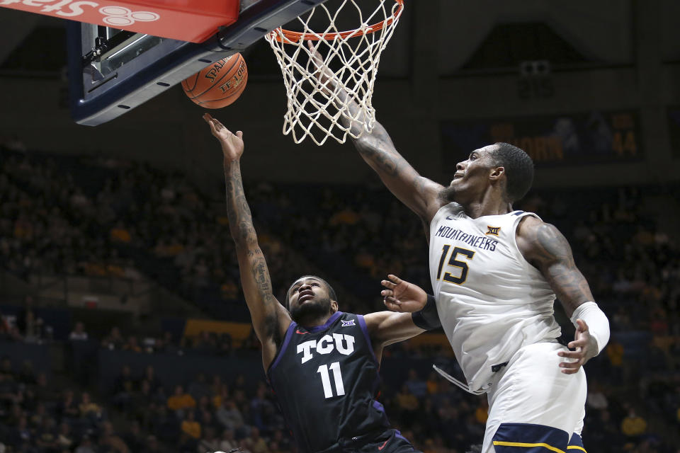 TCU guard Rondel Walker (11) is defended by West Virginia forward Jimmy Bell Jr. (15) during the first half of an NCAA college basketball game Wednesday, Jan. 18, 2023, in Morgantown, W.Va. (AP Photo/Kathleen Batten)