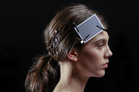 A model uses a playing card to keep her hair in place as she walks the runway during a rehearsal before a presentation of the Honor Spring/Summer 2014 collection during New York Fashion Week, September 5, 2013. REUTERS/Lucas Jackson