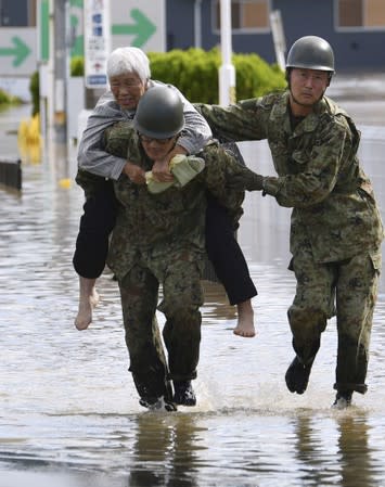 A local resident is rescued by Japanese Self-Defence Forces soldiers from areas flooded by Abukuma river following Typhoon Hagibis in Motomiya